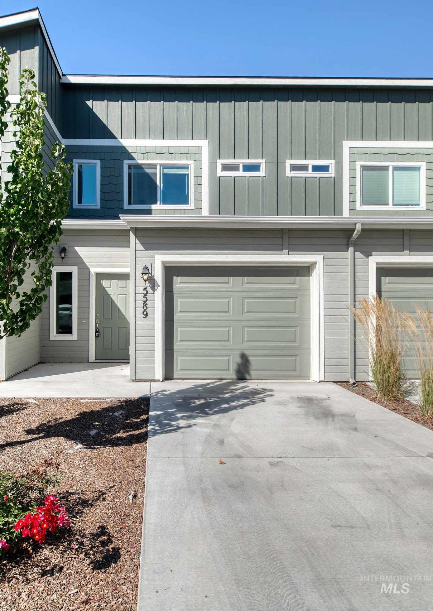 View of front of property with driveway and a garage