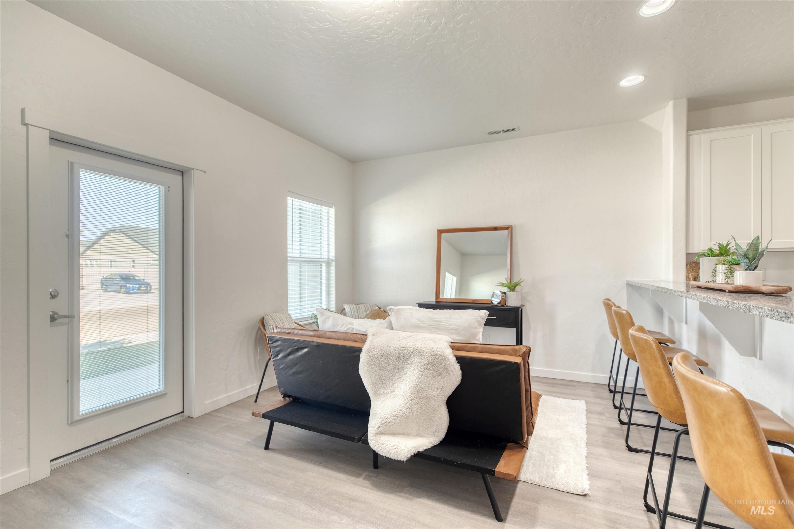 Bedroom with access to exterior, light wood-type flooring, a textured ceiling, and recessed lighting
