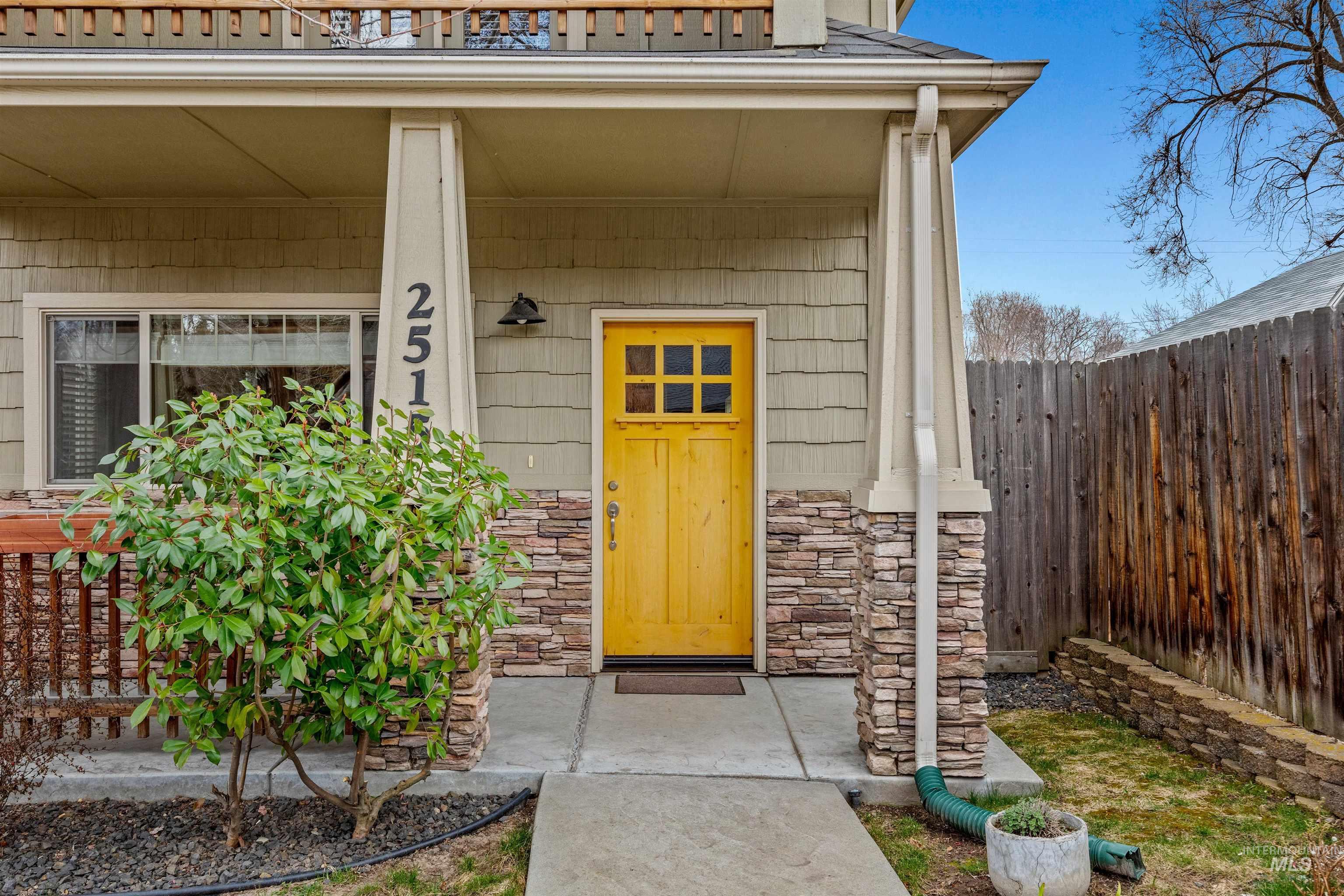 View of exterior entry with stone siding and a porch
