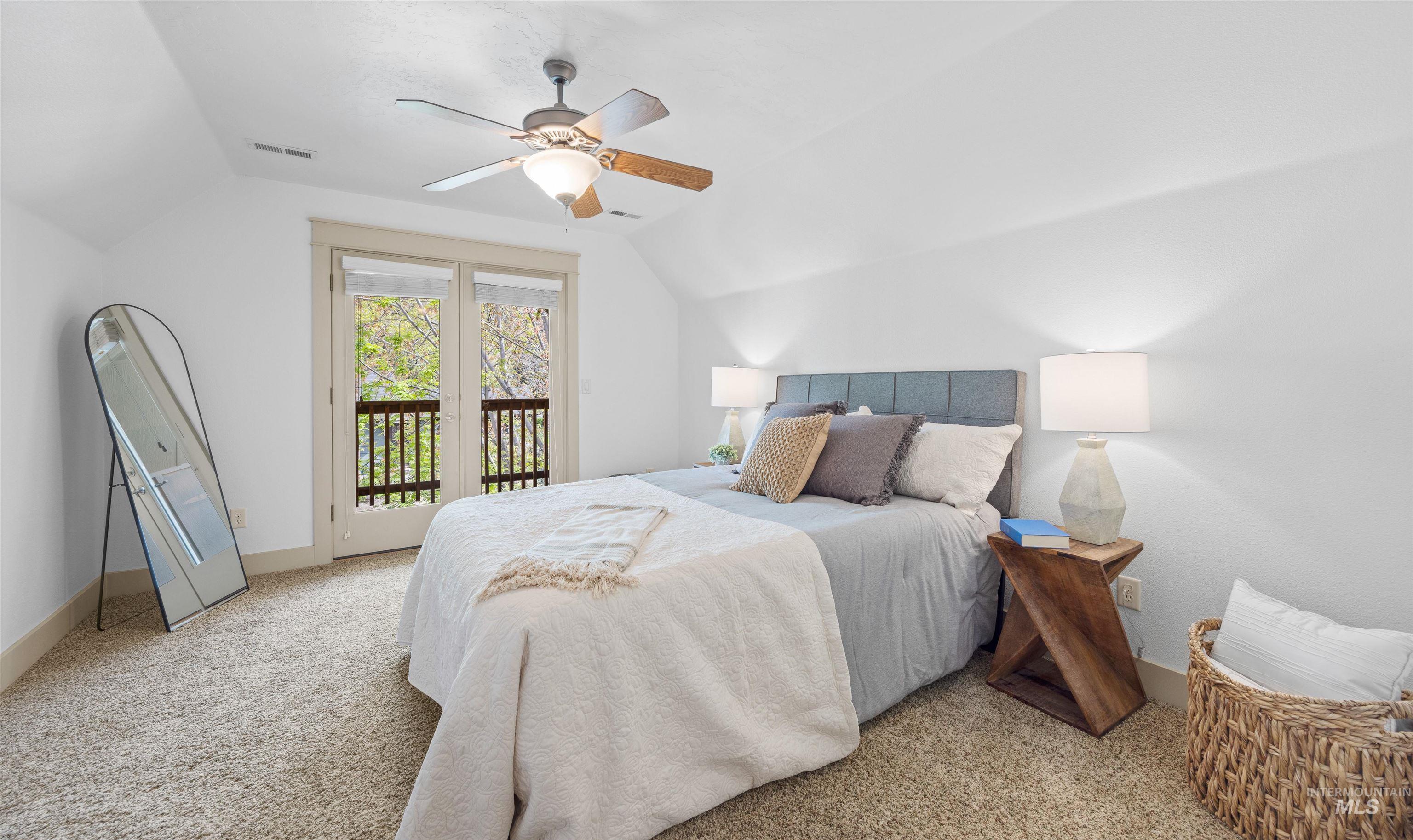 Bedroom with light carpet, vaulted ceiling, access to outside, and ceiling fan