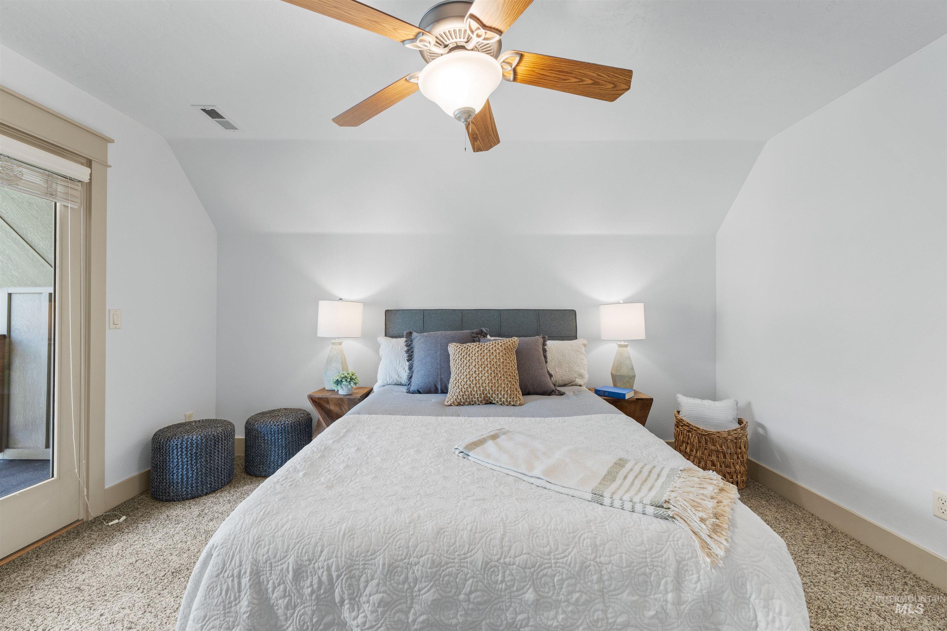 Bedroom featuring lofted ceiling, light colored carpet, a ceiling fan, and access to exterior
