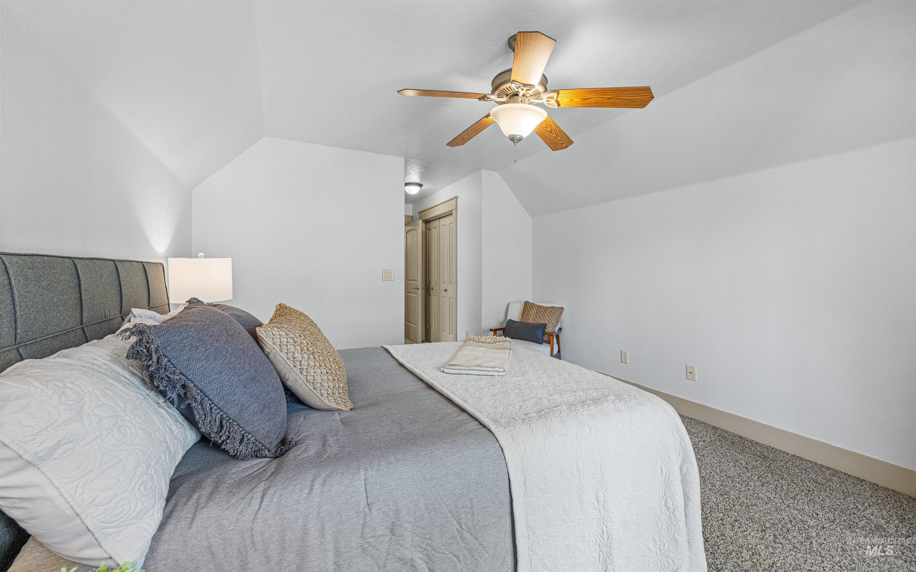 Bedroom featuring lofted ceiling, carpet, ceiling fan, and a closet