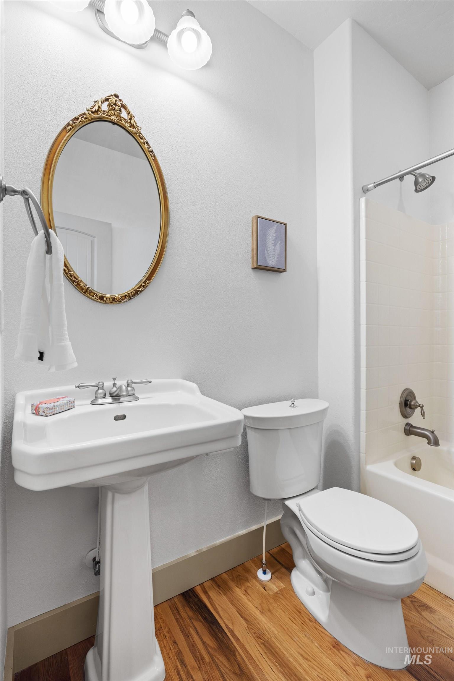 Bathroom featuring light wood-style flooring and  shower combination
