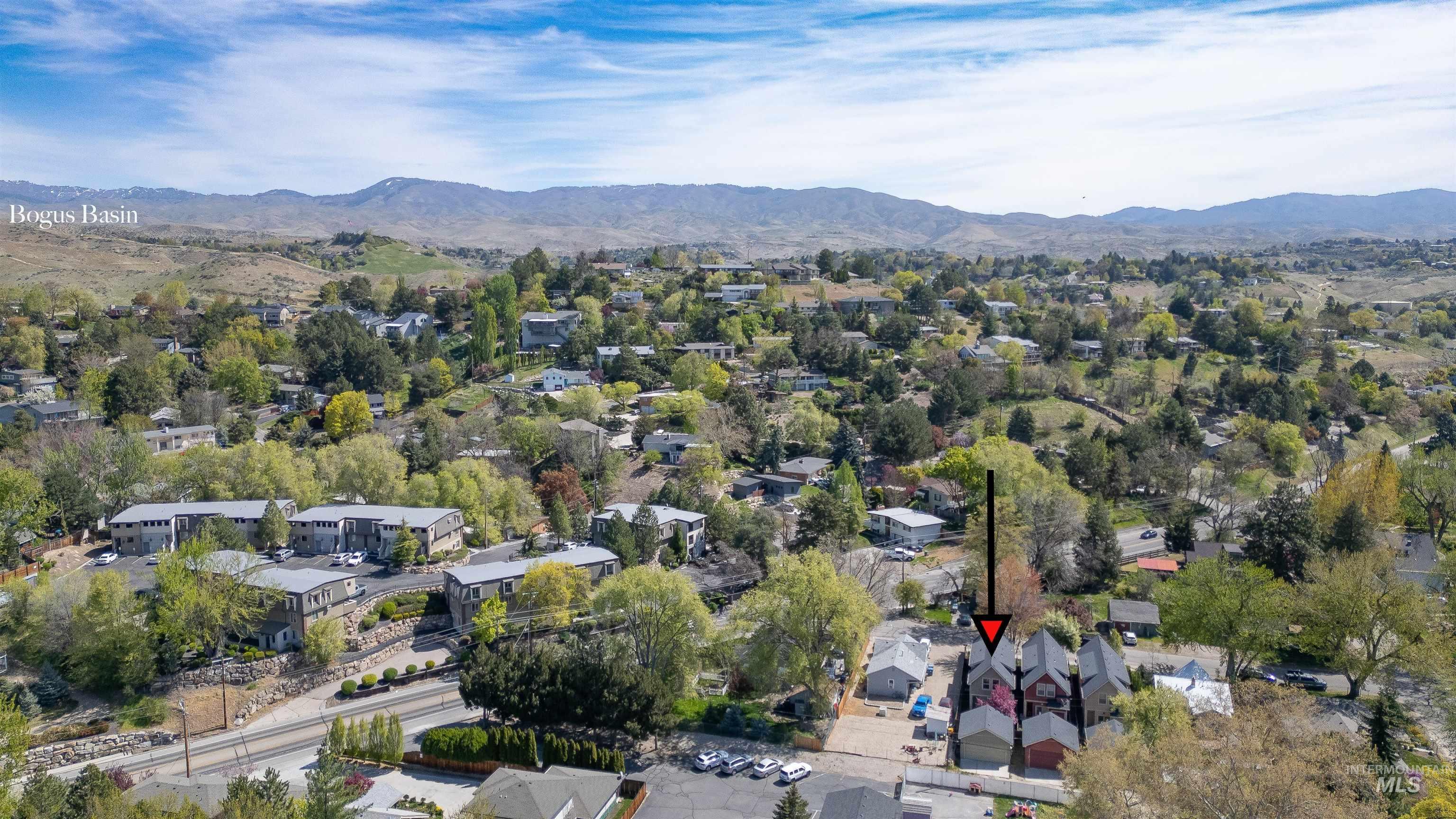 Aerial overview of property's location with a mountain backdrop and nearby suburban area