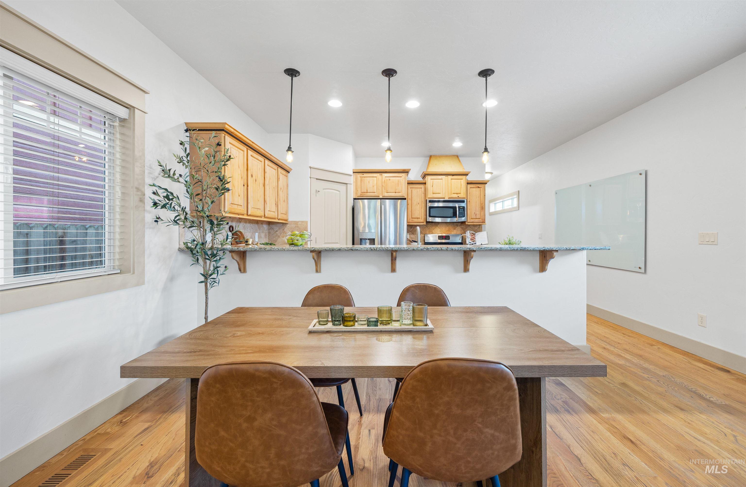 Dining space with light wood-style floors and recessed lighting