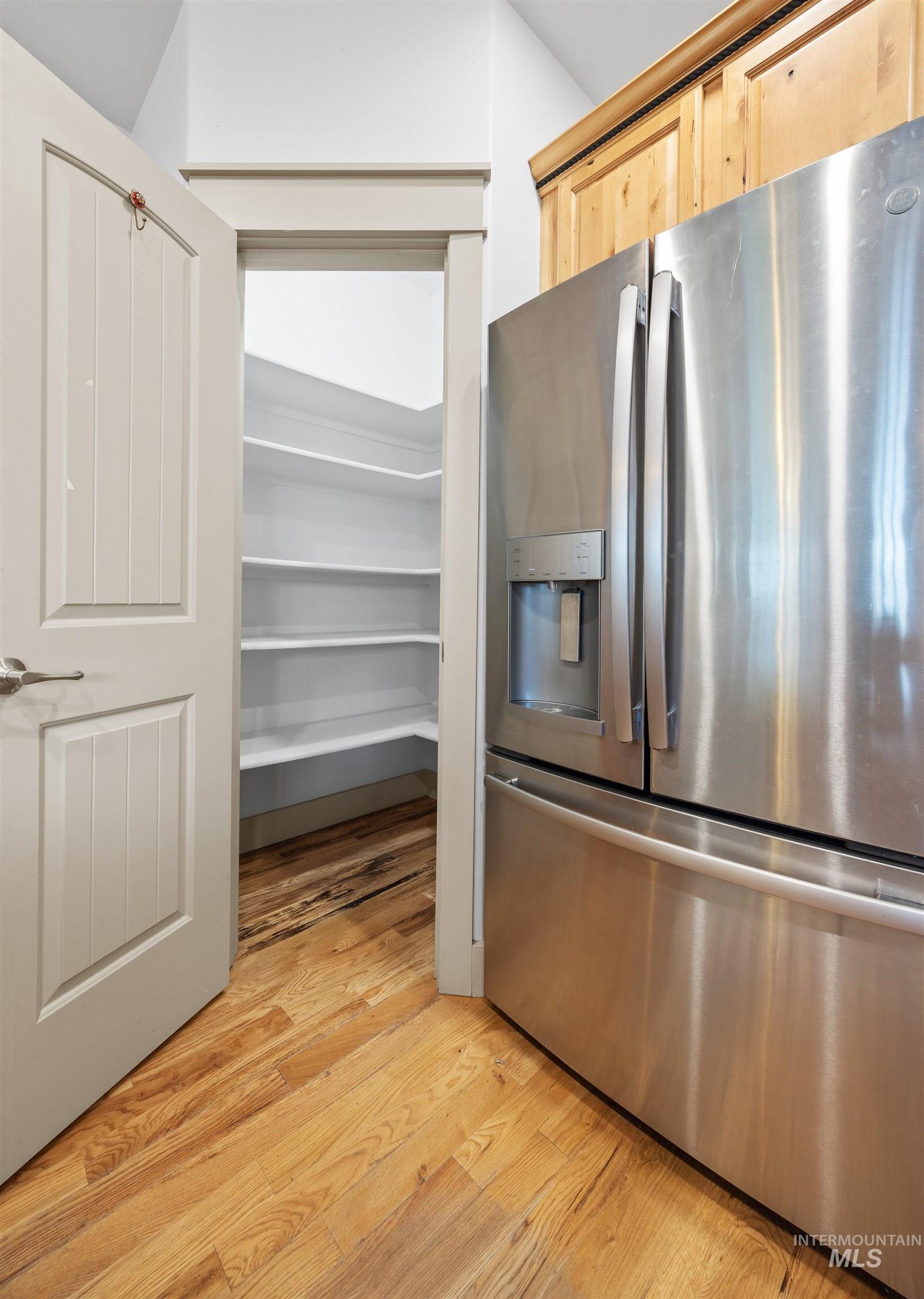 Kitchen with stainless steel fridge and light wood-style floors