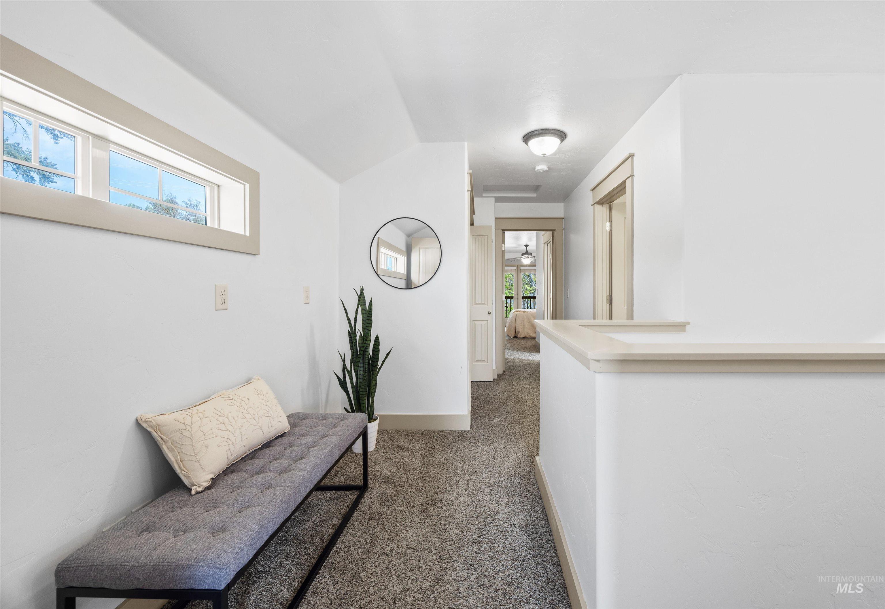Hallway with dark colored carpet and baseboards