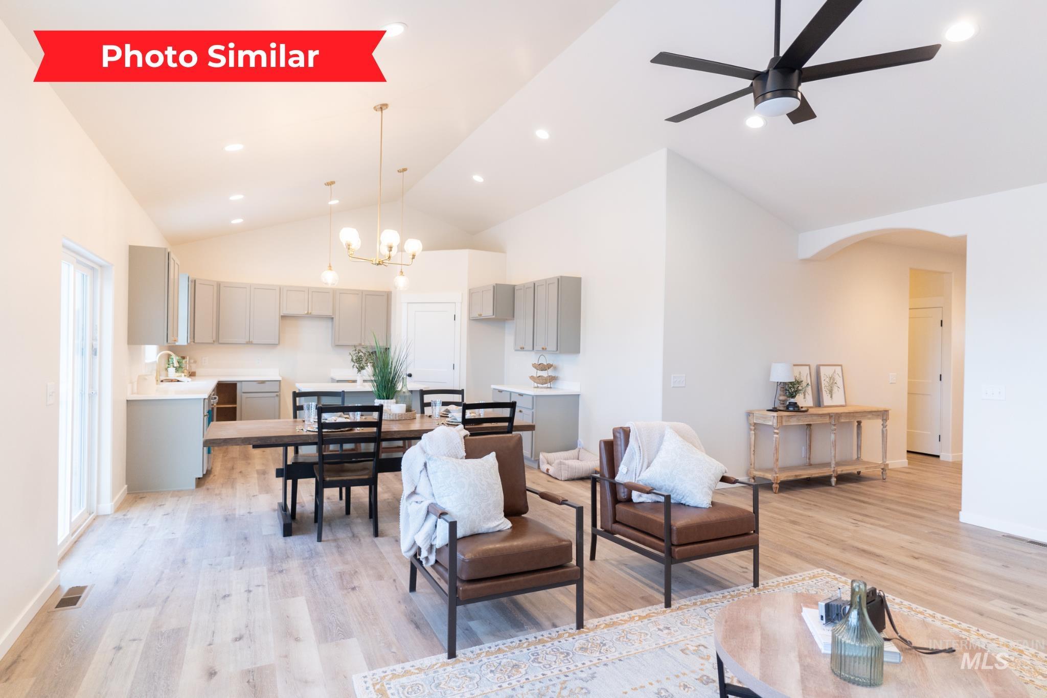 Living area with light wood-style floors, high vaulted ceiling, a chandelier, arched walkways, and a ceiling fan