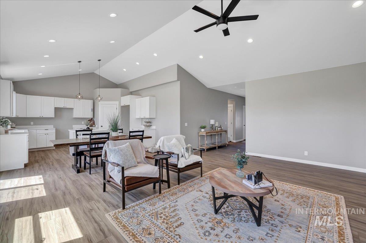 Living room featuring high vaulted ceiling, light wood finished floors, recessed lighting, and a ceiling fan