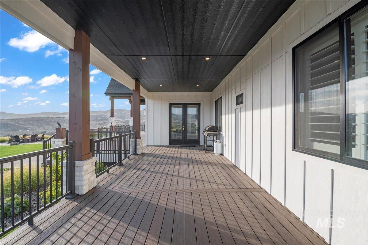 Deck with a mountain view, area for grilling, and french doors