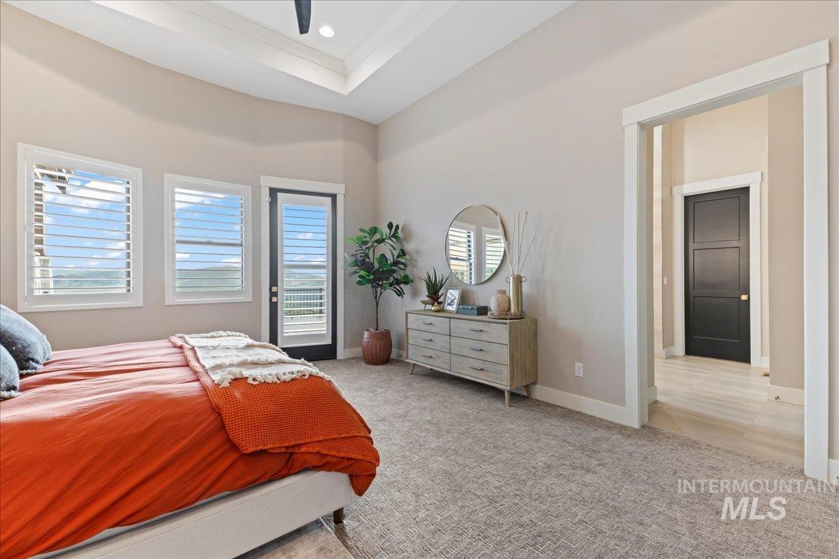 Bedroom with light colored carpet, a ceiling fan, a raised ceiling, and recessed lighting