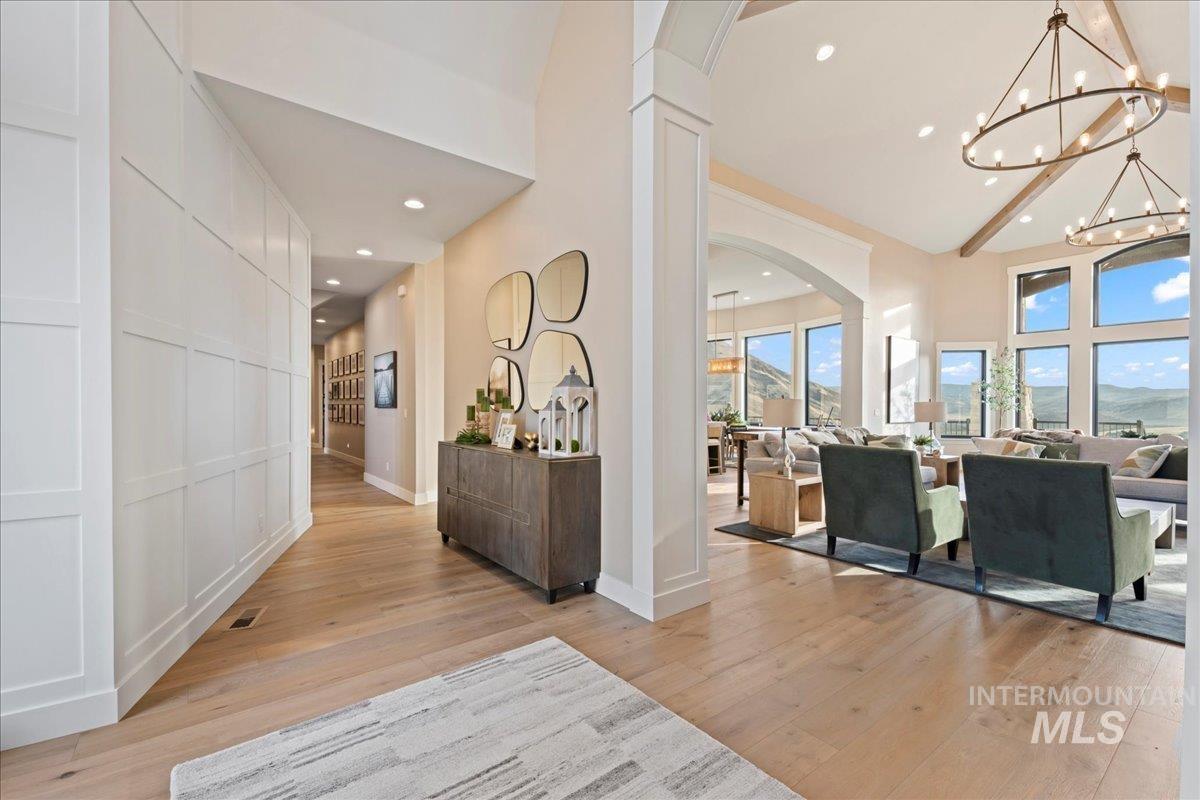 Foyer featuring a chandelier, arched walkways, recessed lighting, and light wood finished floors