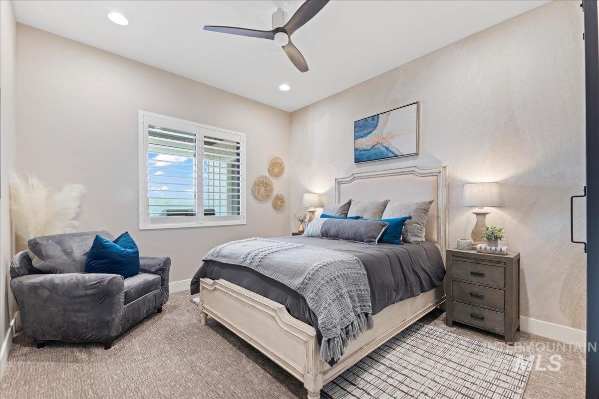 Carpeted bedroom featuring ceiling fan and recessed lighting
