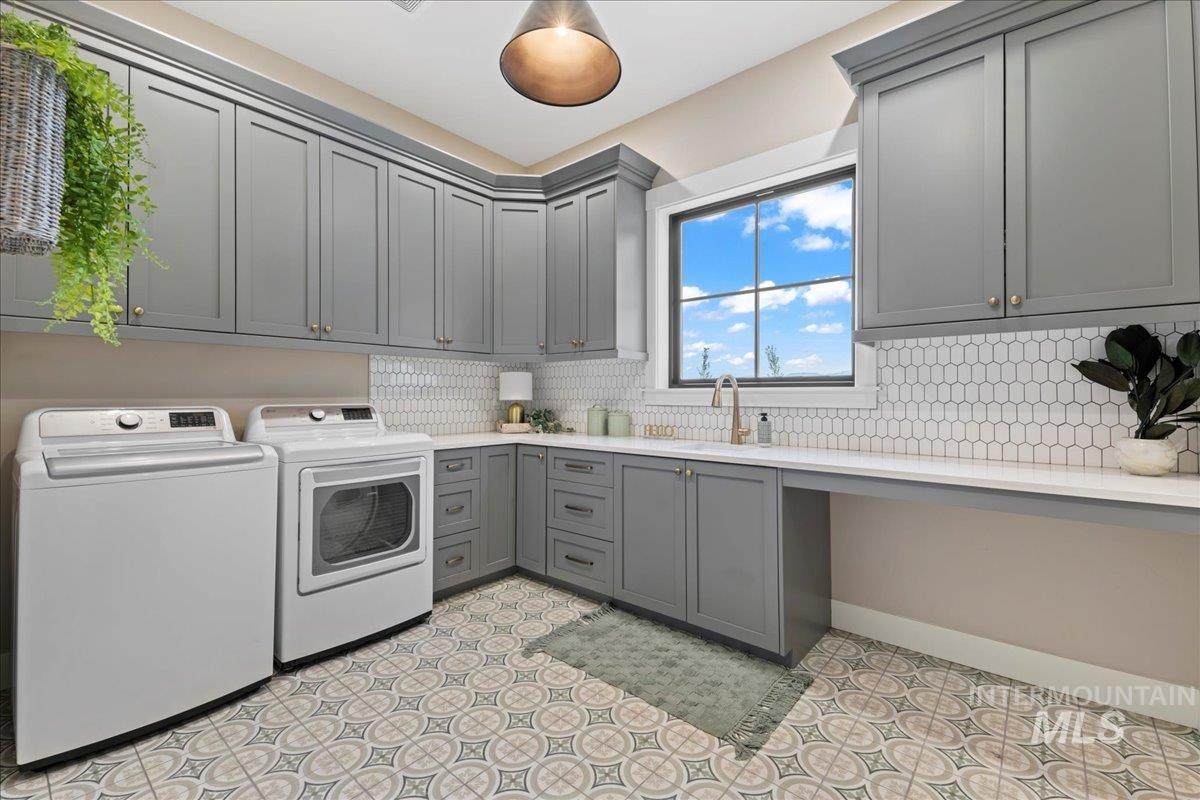 Laundry room featuring independent washer and dryer and cabinet space