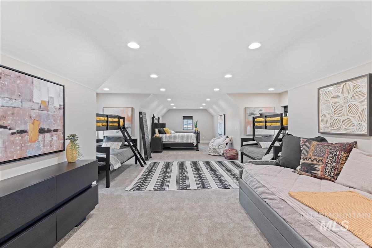 Living area featuring light colored carpet, vaulted ceiling, and recessed lighting