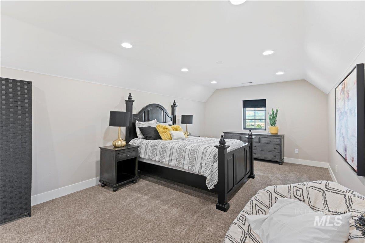 Bedroom featuring light colored carpet, lofted ceiling, and recessed lighting