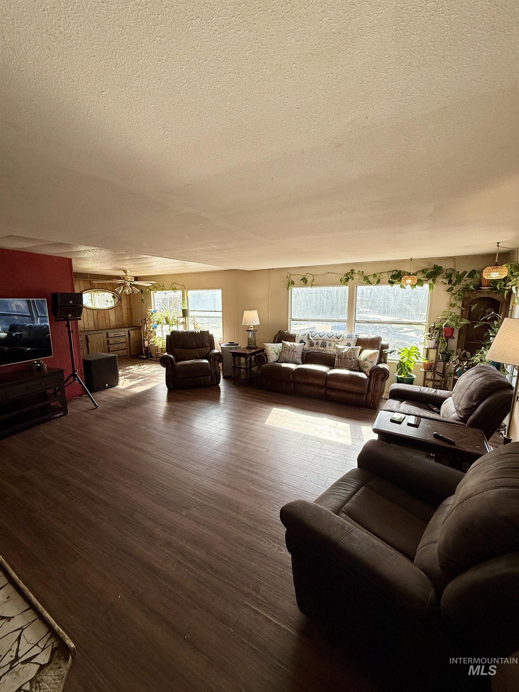Living area featuring wood finished floors and a textured ceiling