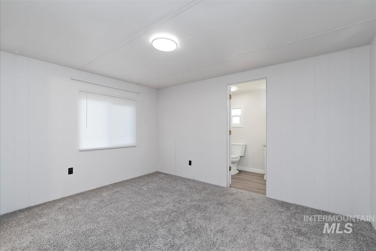 Unfurnished bedroom featuring carpet and connected bathroom