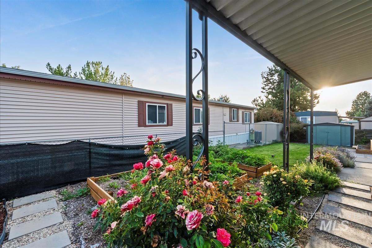 View of side of property with a storage shed and a vegetable garden