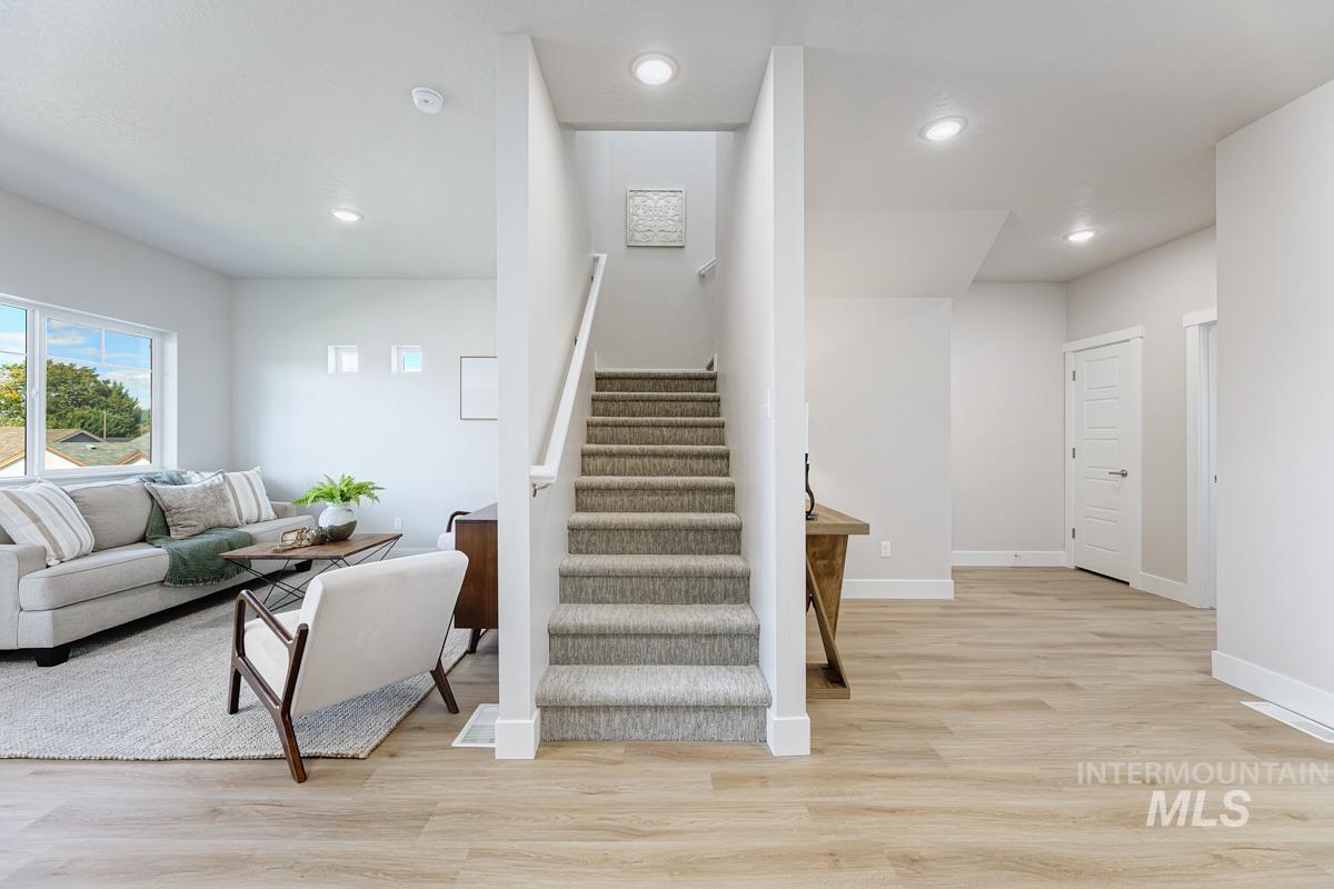 Stairway with wood finished floors and recessed lighting
