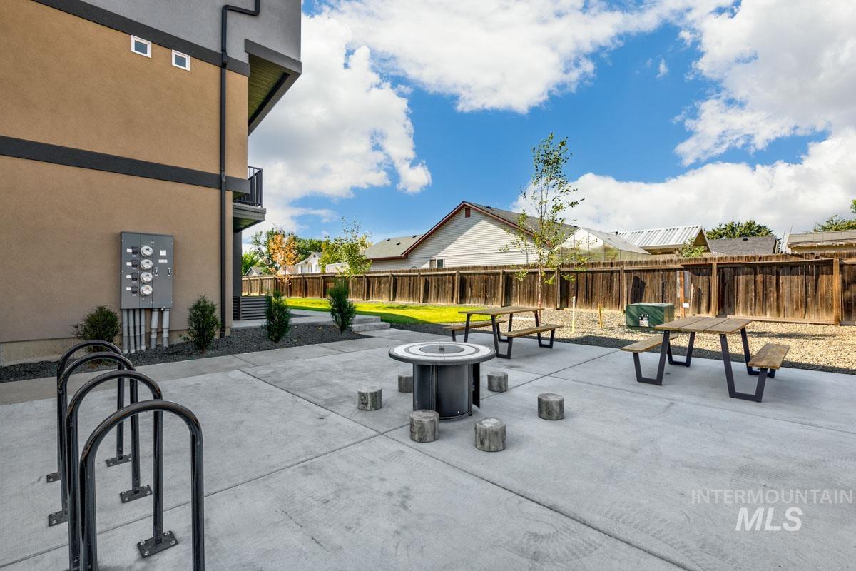 Fenced backyard featuring a fire pit, a patio, and a residential view