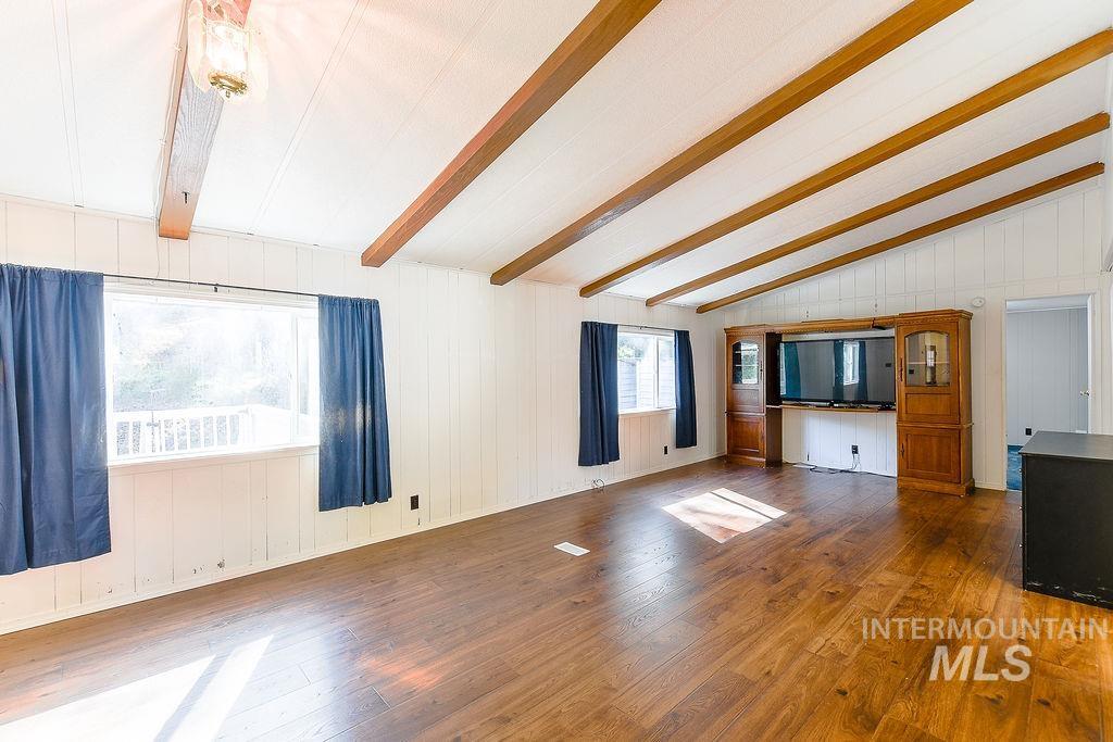 Unfurnished living room with hardwood / wood-style flooring and wood walls
