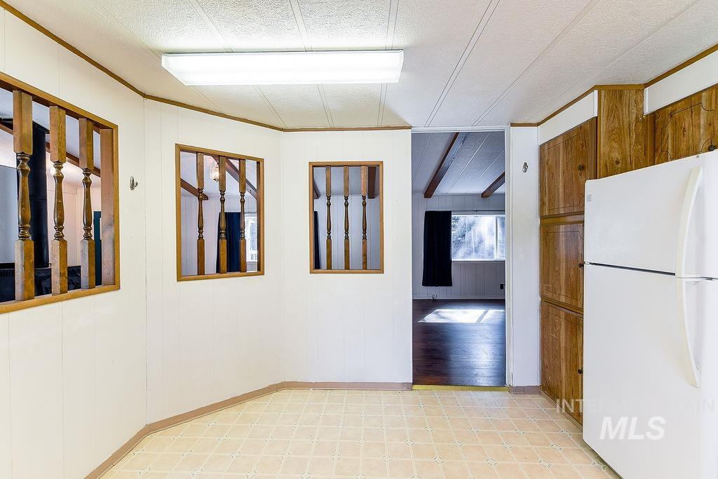 Corridor featuring wooden walls, crown molding, and light flooring