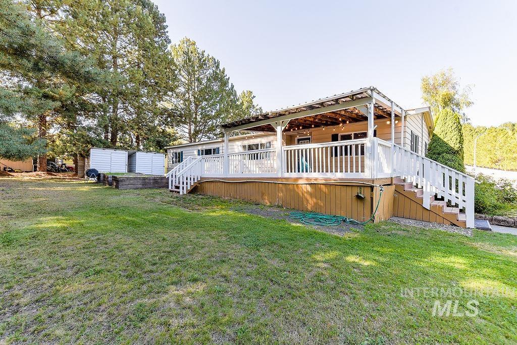 Rear view of property with stairs, a yard, and a wooden deck