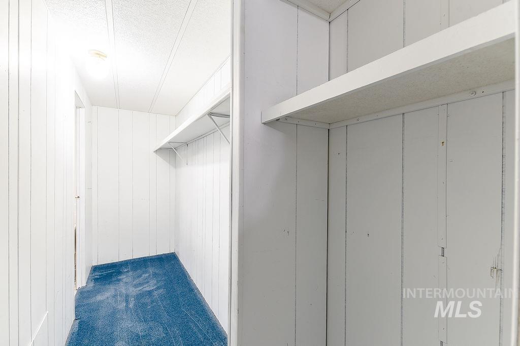 Walk in closet with dark colored carpet