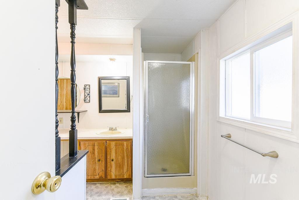 Bathroom featuring vanity and a stall shower