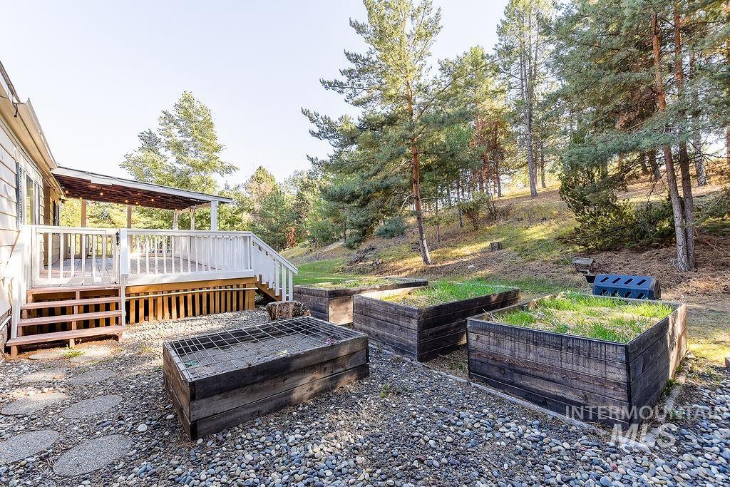 View of yard featuring a garden, a deck, and stairway