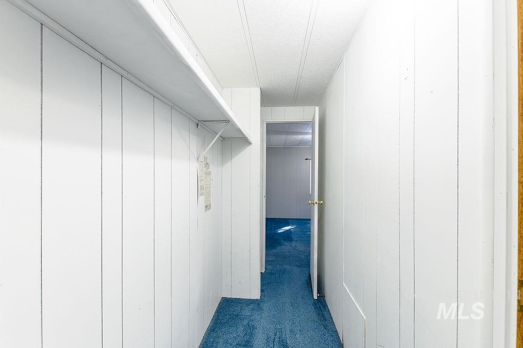 Spacious closet with dark colored carpet