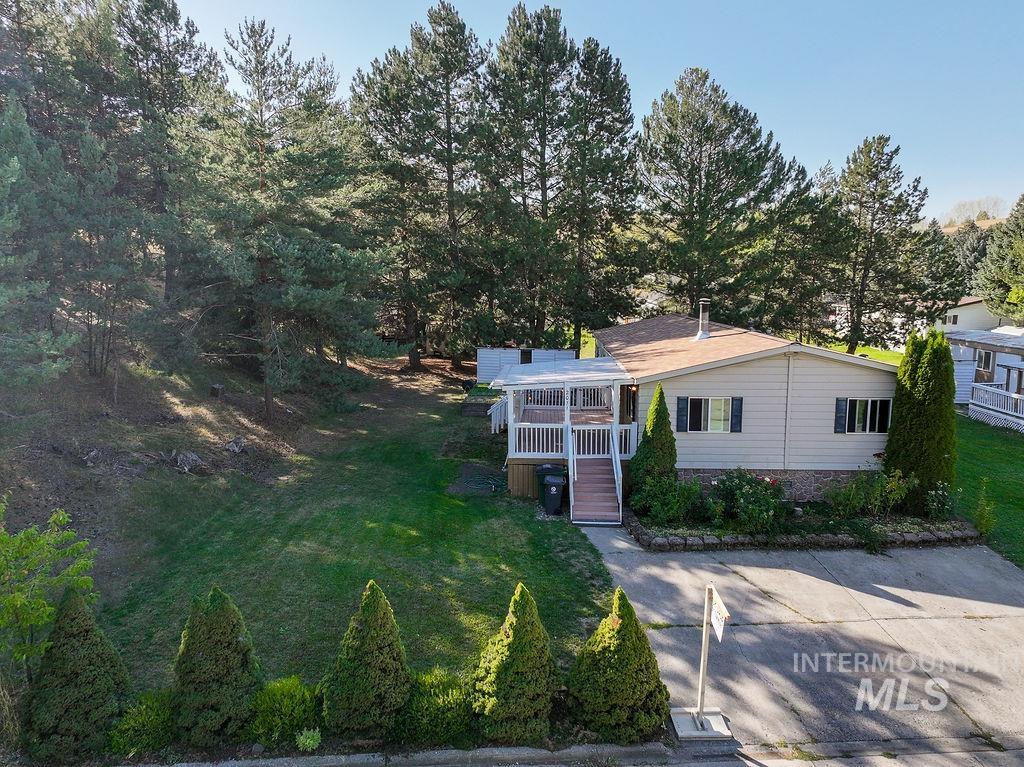 Bungalow featuring a front yard, a deck, and stairs