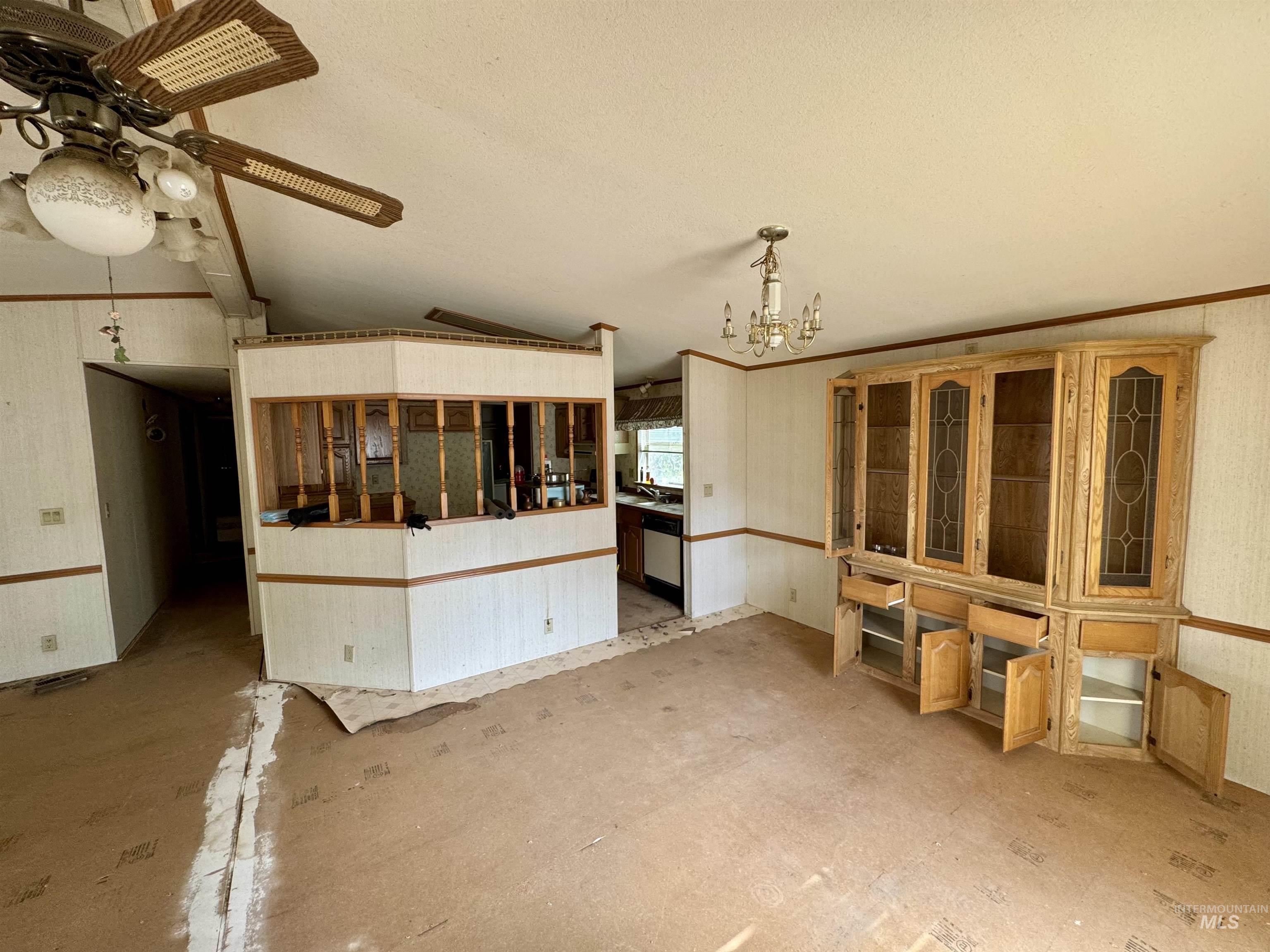Unfurnished dining area with vaulted ceiling, a chandelier, a ceiling fan, and wallpapered walls