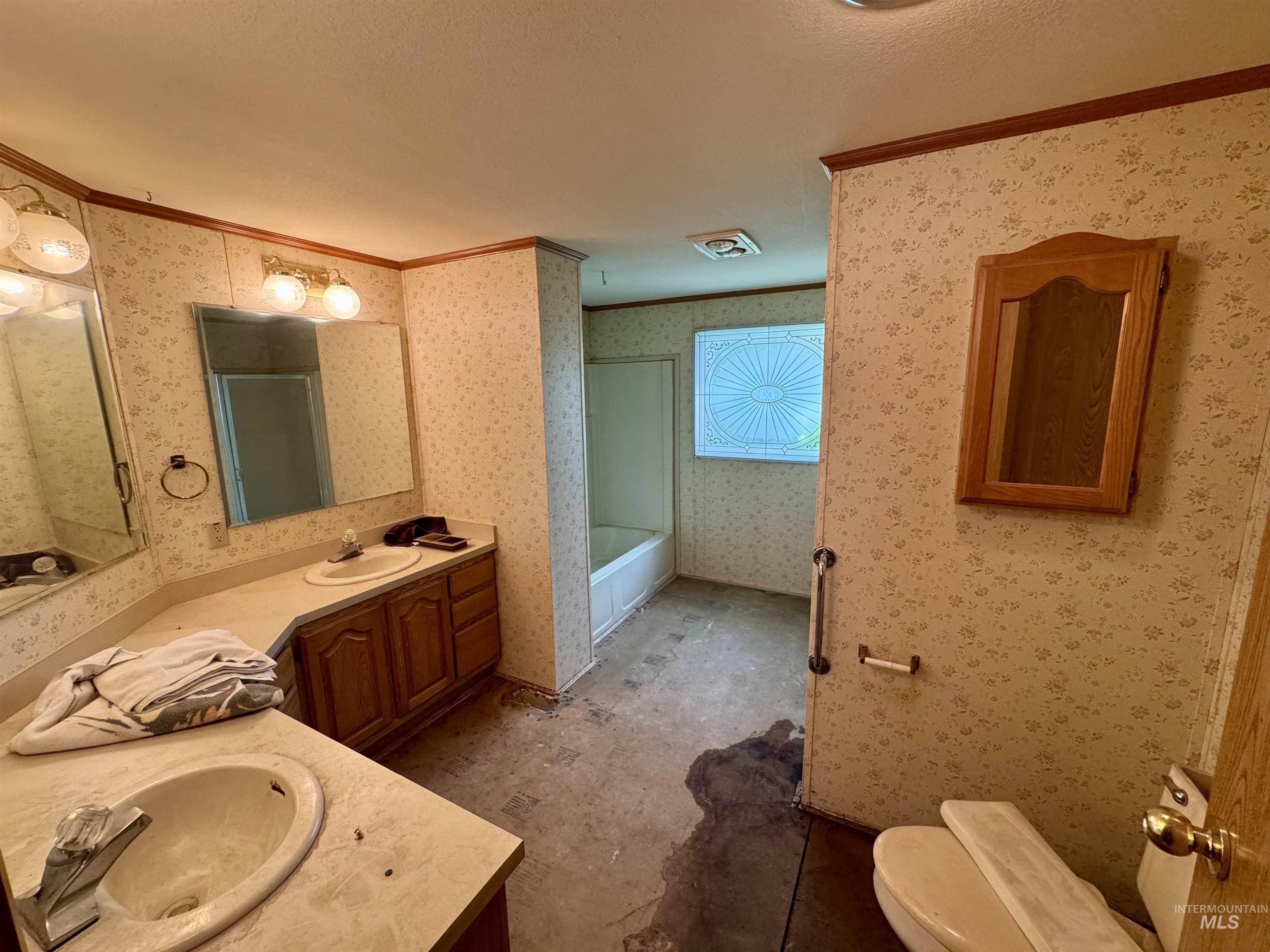 Bathroom with vanity, ornamental molding, a garden tub, wallpapered walls, and an enclosed shower