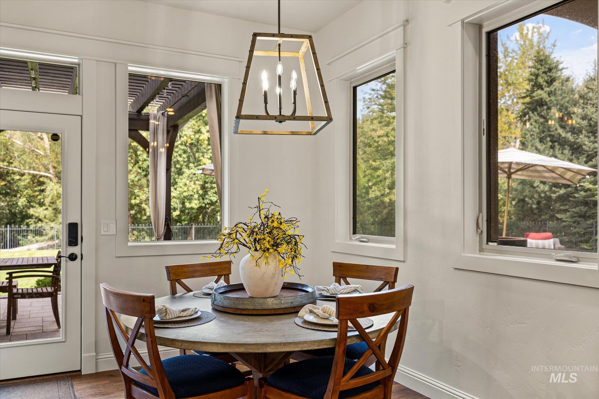 Dining room with a chandelier, healthy amount of natural light, and wood finished floors