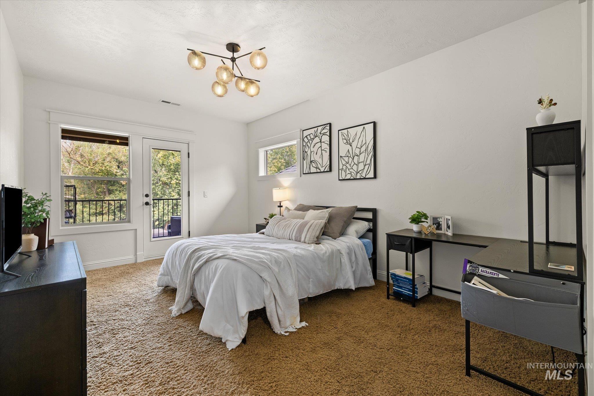 Bedroom featuring carpet floors, access to outside, and a chandelier