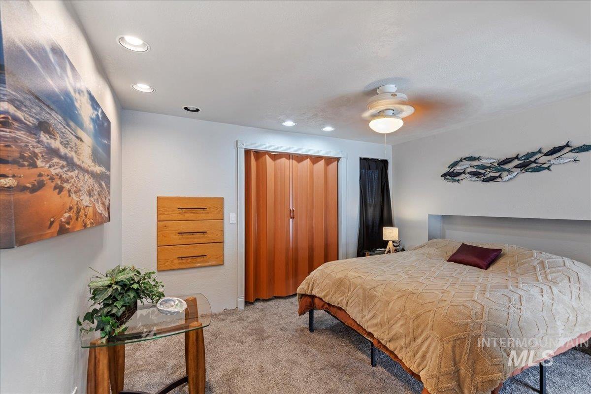 Carpeted bedroom with ceiling fan and recessed lighting