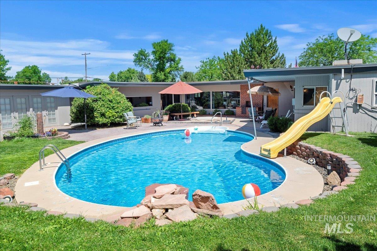 Swimming pool featuring a patio area and a yard
