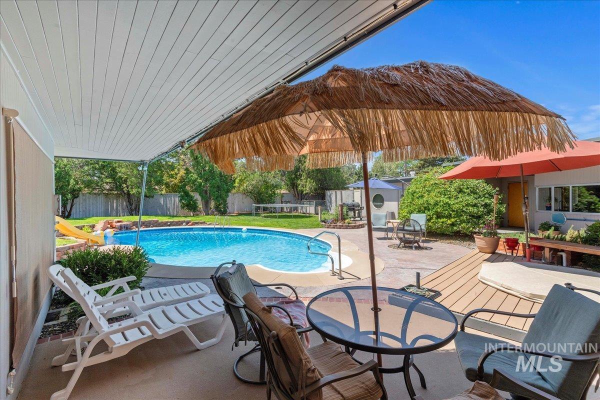 View of swimming pool with a patio area, outdoor dining space, and a fenced backyard