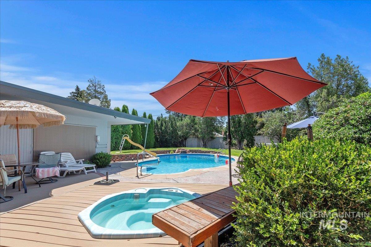 View of pool featuring a wooden deck, a patio, and a water slide