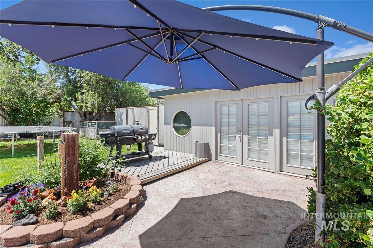 View of patio with grilling area, french doors, and a wooden deck