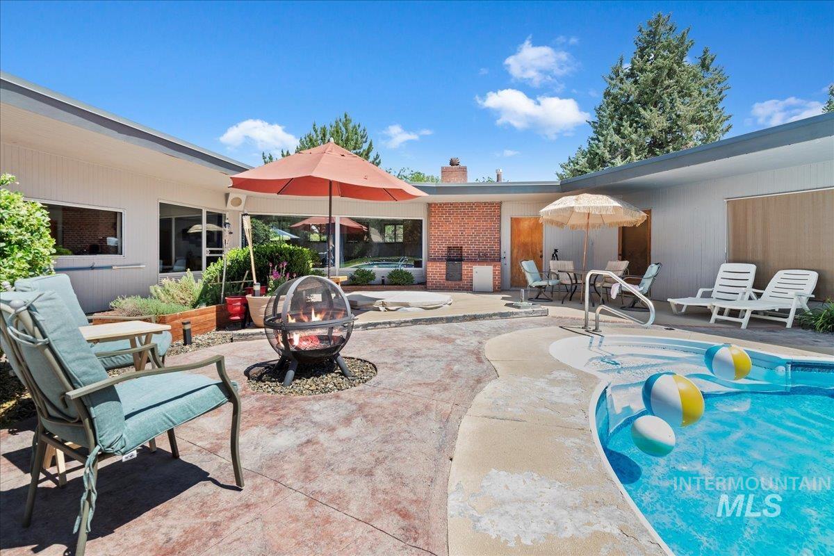 Swimming pool with a patio and a fire pit