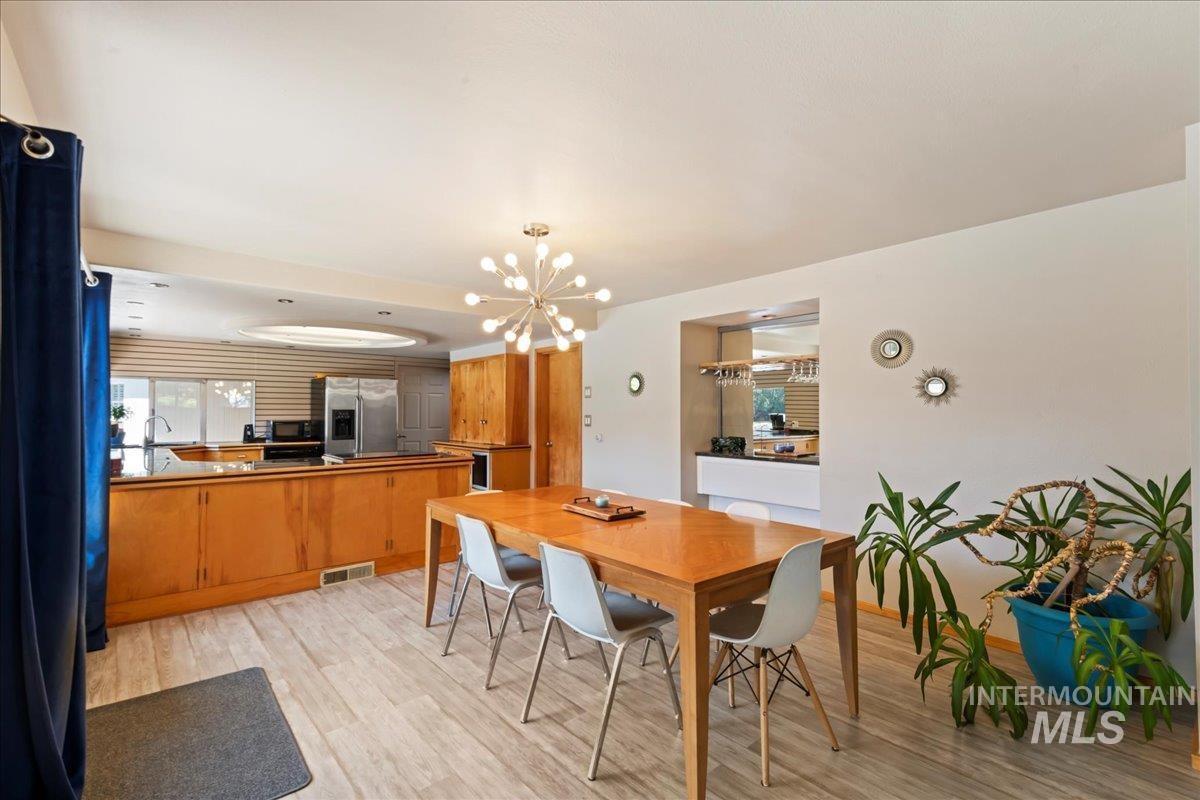 Dining room featuring light wood-style floors and a chandelier