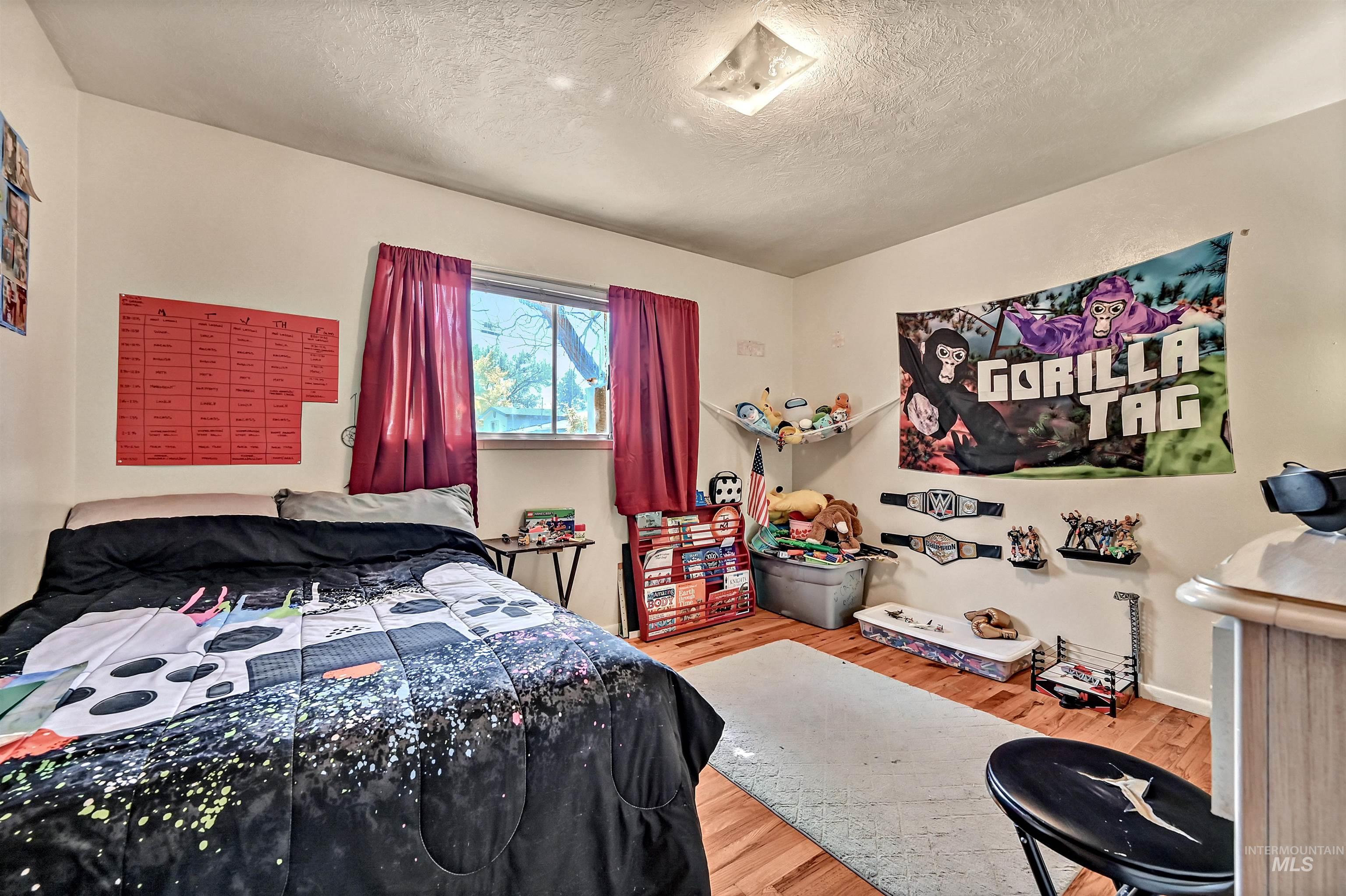 Bedroom with light wood-style flooring and a textured ceiling