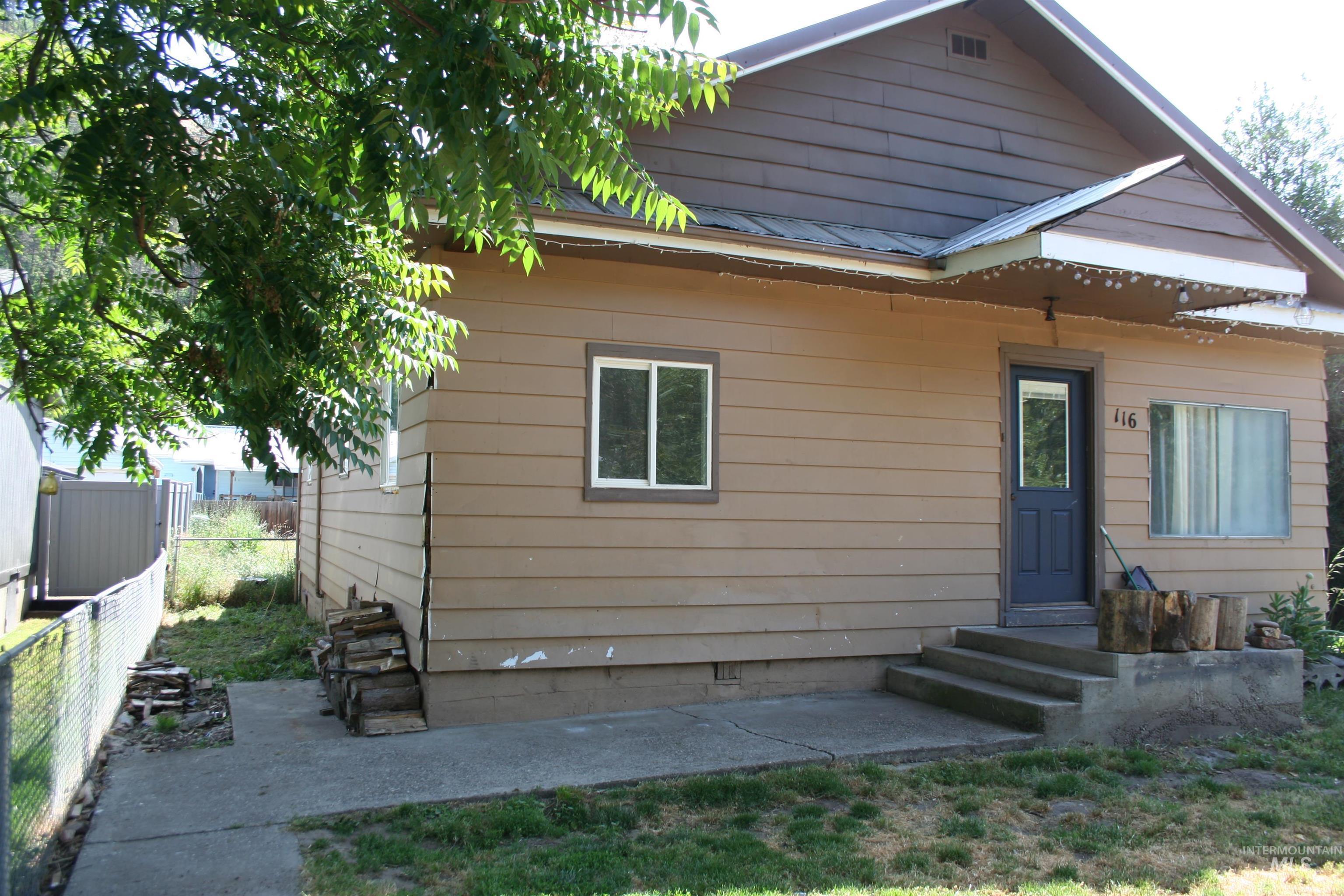 Rear view of property with entry steps and a metal roof