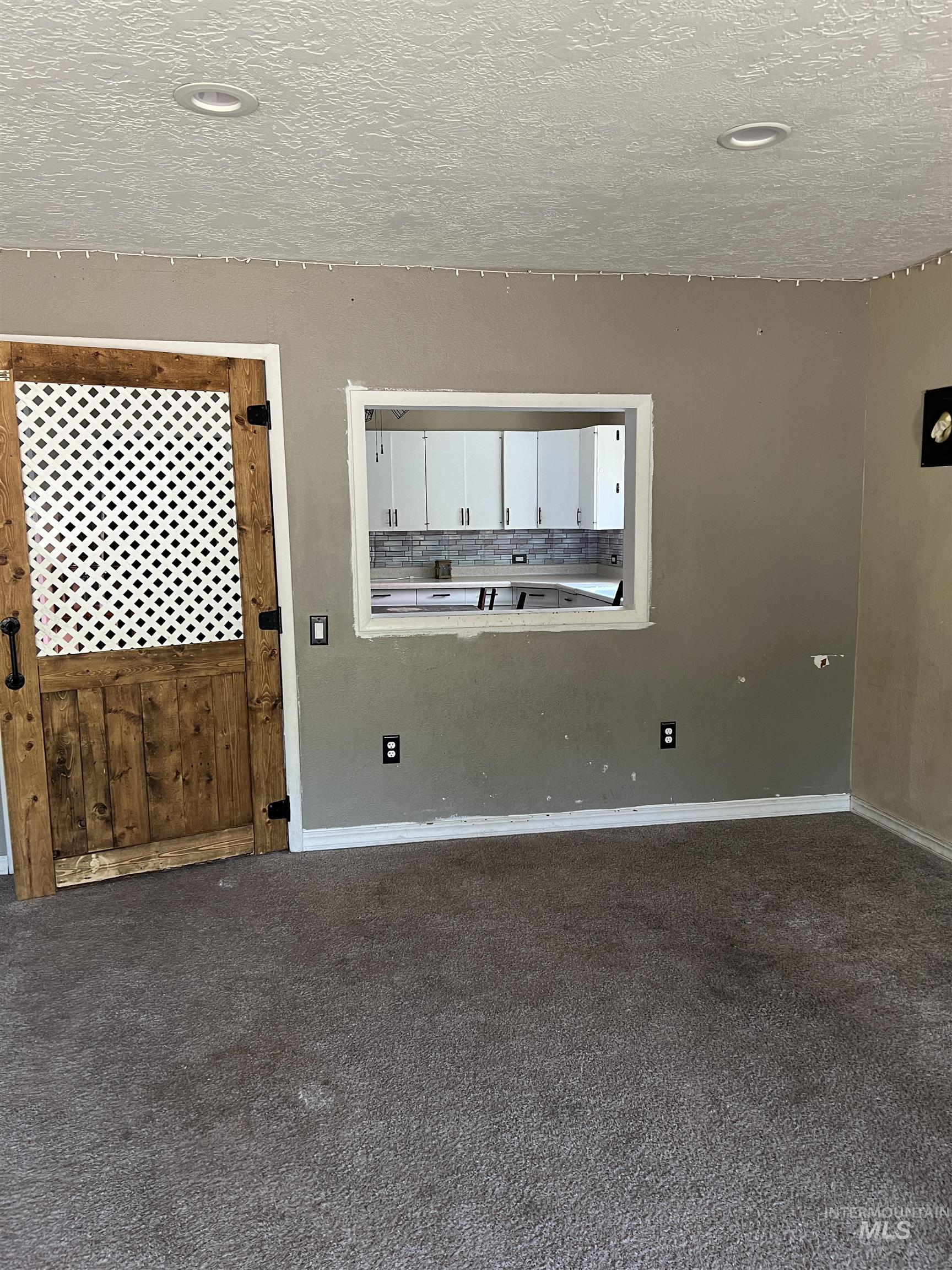 Carpeted spare room featuring a textured ceiling