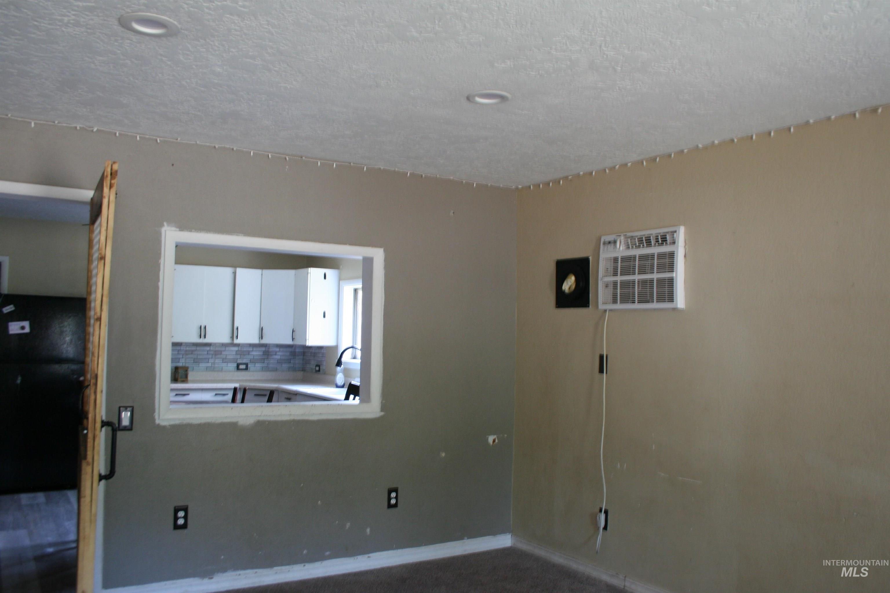 Unfurnished room featuring a wall mounted air conditioner and a textured ceiling