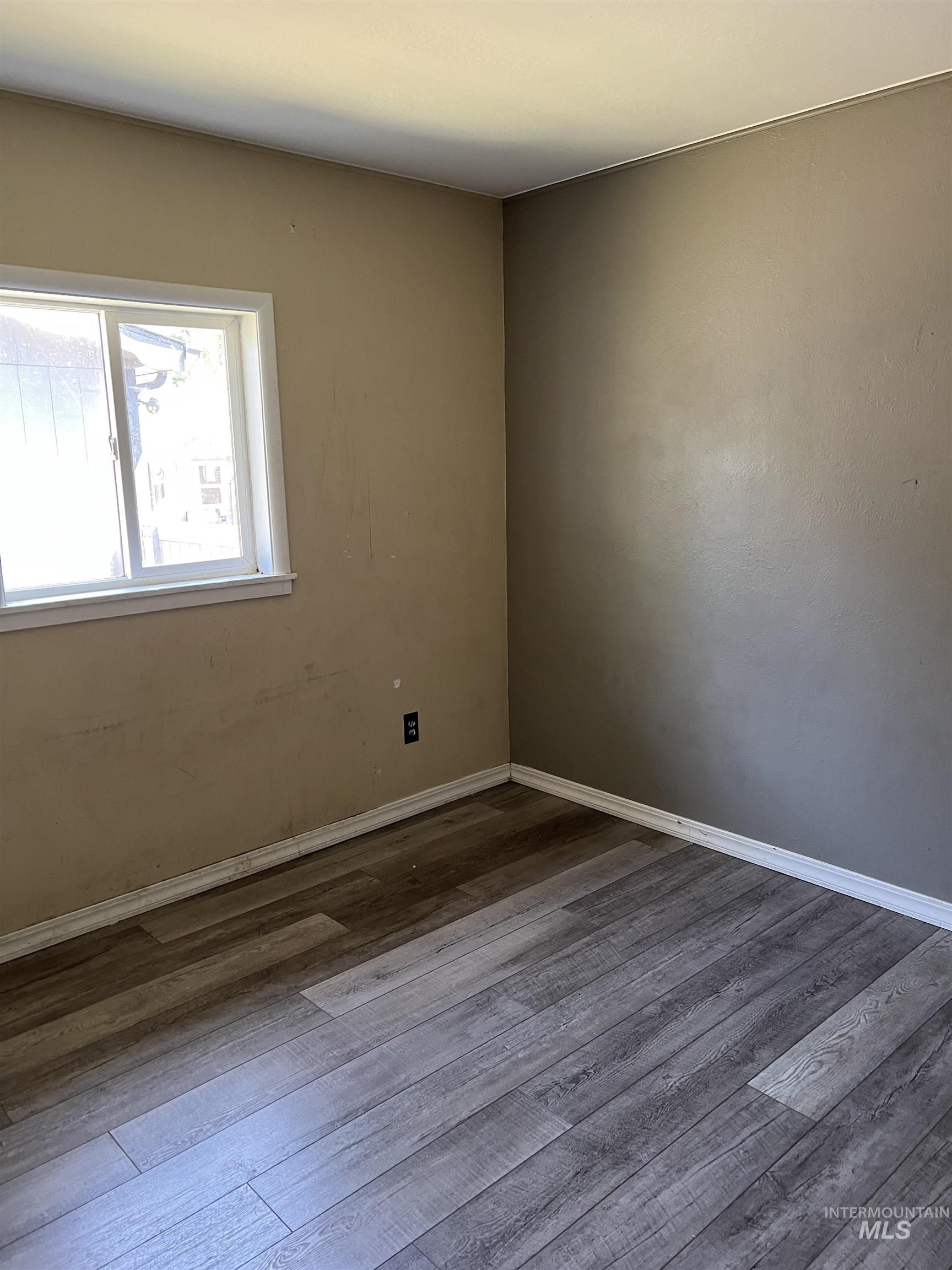 Empty room with dark wood-style flooring