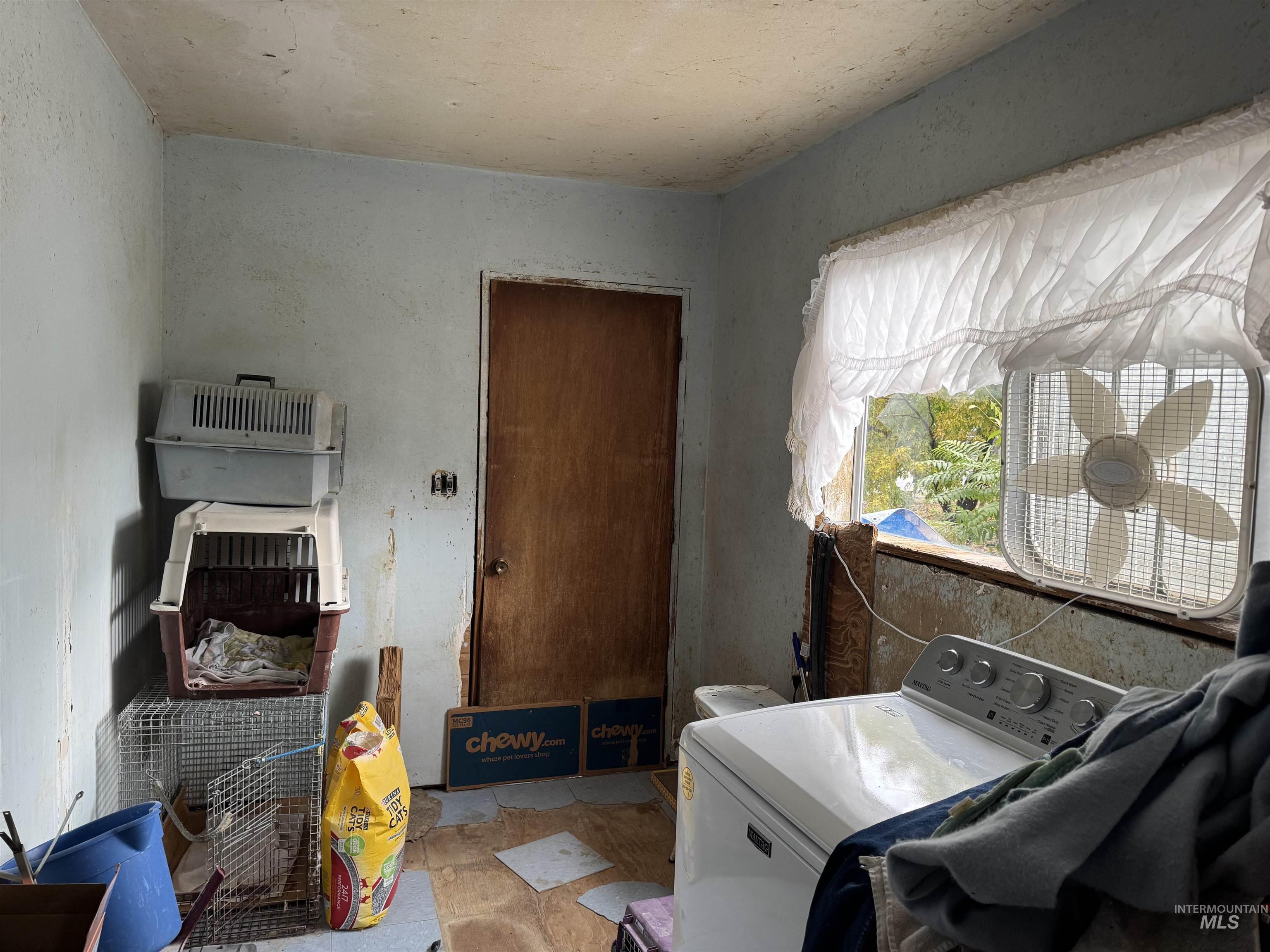 Laundry area featuring washer / clothes dryer and stone finish flooring